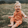 US stockist of My Brother John's Ziggy Stomper. Tank romper in a warm orange color with cozy fleece lining and rolled leg cuffs.  Great worn layered.