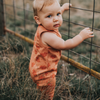 US stockist of My Brother John's Ziggy Stomper. Tank romper in a warm orange color with cozy fleece lining and rolled leg cuffs.  Great worn layered.