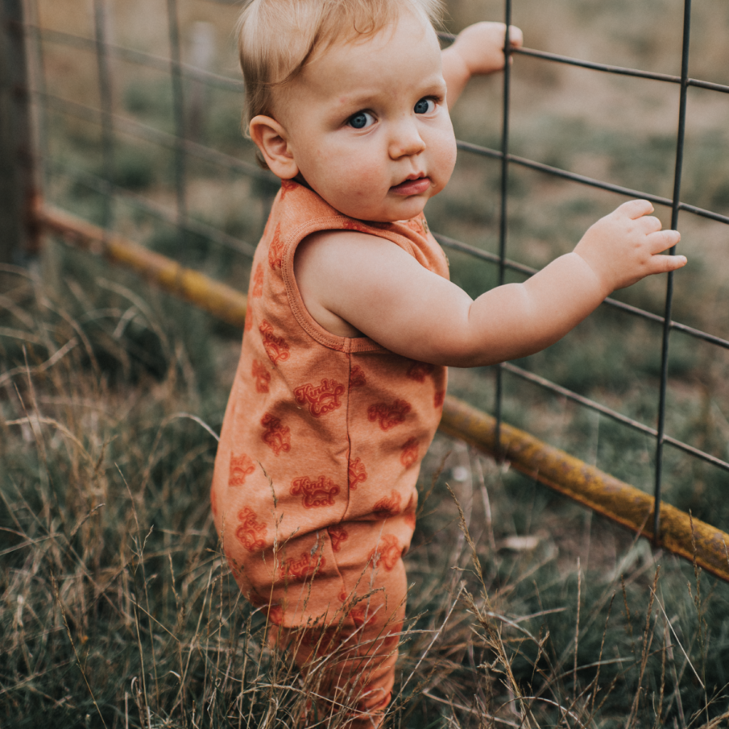 US stockist of My Brother John's Ziggy Stomper. Tank romper in a warm orange color with cozy fleece lining and rolled leg cuffs.  Great worn layered.
