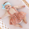 US stockist of Lacey Lane's Peach suspender skirt.  Peach cotton fabric with a pretty design of white and blue flowers.  Features pockets and oversized buttons down front.