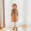 US stockist of Lacey Lane's Peach suspender skirt.  Peach cotton fabric with a pretty design of white and blue flowers.  Features pockets and oversized buttons down front.