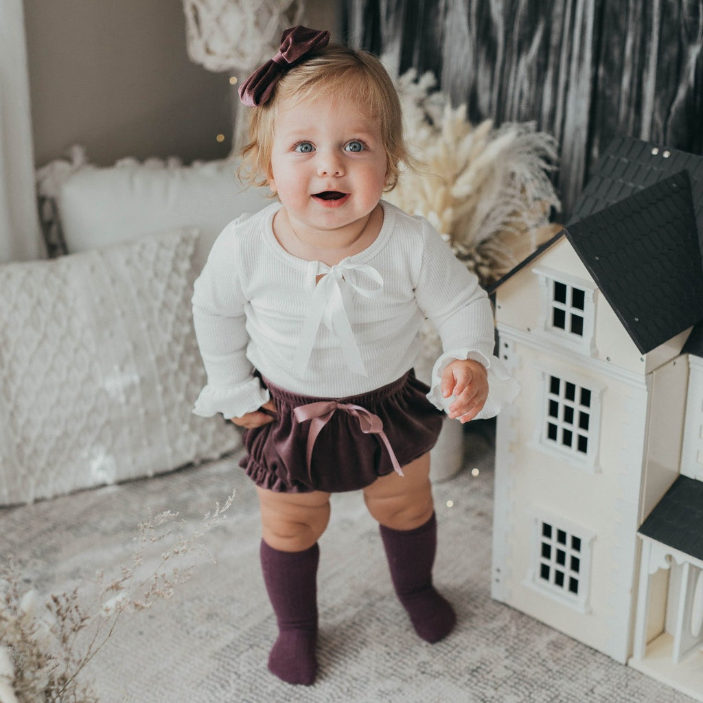 US stockist of Karibou Kids' whimsy love ruffle sleeve, cotton waffle top in snow white.  Features keyhole tie front of neck.